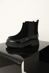 Botas negras de cuero con elástico lateral y suela track.