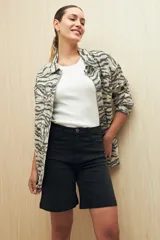 Bermuda de denim azul oscuro, de tiro alto y largo a la rodilla. Presenta bolsillos funcionales y costuras marcadas.