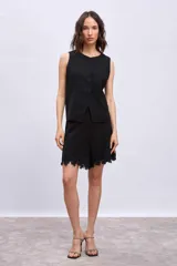 Bermuda negra con apliques de encaje en el ruedo.