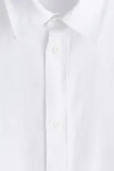 Camisa blanca de lino con cuello inglés, tapeta clásica y canesú en la espalda. Mangas largas con tapeta de manga y botón, y cierre ajustable de botón en los puños. Bajo redondeado. Corte estándar.