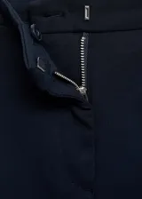 Pantalón negro de corte skinny, tiro medio y largo a la altura del tobillo.