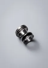 Anillo plateado de acero quirúrgico con franja central negra. Diseño unisex, moderno y minimalista.