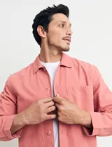 Sobrecamisa verde de manga larga con cuello camisero, cierre frontal con botones y bolsillo de parche en el pecho.