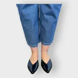 Chatas de cuero negro con punta fina y diseño elegante.