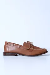 Mocasín de cuero color marrón claro, con cordones y detalle de costuras en la puntera.