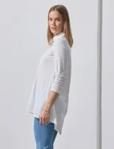 Camisola blanca de manga tres cuartos, marca Rio & Rian. Cuello con solapa y abertura central con botones. Manga con detalle fruncido.