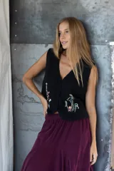Chaleco tejido negro con detalles multicolores y botones forrados, diseñado para añadir textura y estilo a cualquier atuendo.
