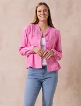 Chaqueta color beige de lino y rayón, con cuello mao, cierre frontal con botones y bolsillos delanteros.