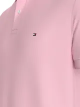 Chomba rosa de Tommy Hilfiger, corte regular, con cuello tipo chomba, cartera de dos botones, logo bordado en el pecho y detalles distintivos de la marca.