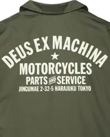 Campera verde militar estilo coach con cuello clásico, cierre con botones a presión, bolsillos laterales y puños elásticos. Estampado con el logo de la marca Deus Ex Machina en el pecho.