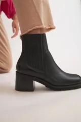 Bota corta de cuero negro con elástico en los laterales y taco cuadrado.