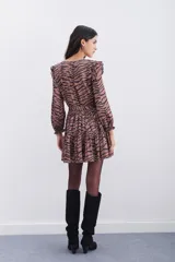 Vestido corto color marrón con estampado de cebra, escote en V, mangas largas con volados en los hombros y puños elásticos con volados.