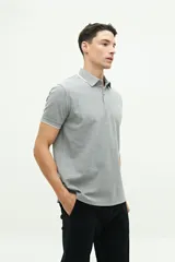 Remera polo verde militar con textura, corte regular, cuello clásico con detalles en azul marino y logo estampado en el pecho.