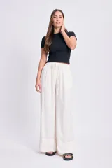 Pantalón de lino color blanco, de corte palazzo con cintura elastizada y cordón ajustable.