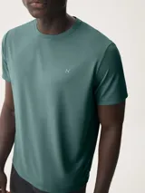 Remera deportiva azul de corte clásico con cuello redondo y logo pequeño en el pecho.