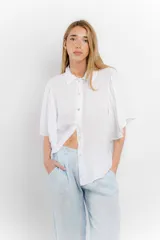 Camisa blanca de lino con cuello clásico y mangas cortas acampanadas.