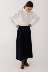 Falda midi color beige, tejida con punto acanalado vertical y pespunte a contratono en el ruedo.