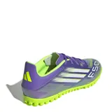 Championes de fútbol 5 Adidas F50 Club en color violeta con detalles en verde lima. Presentan una parte superior sintética con gráficos de velocidad, cierre de cordones y suela de goma con tapones pequeños optimizada para canchas de césped sintético.