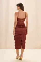 Vestido midi color terracota con flecos en capas, escote halter, bustier tejido con recorte central y aro dorado decorativo.