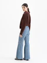 Pantalón ancho de cuero ovino con terminación símil denim, color azul. Presenta recortes curvos en las piernas, cierre y botón tipo jeanero, y bolsillos plaqué en la espalda.