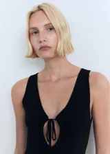Vestido midi negro de punto, con escote en V y detalle de lazo en el centro del busto.