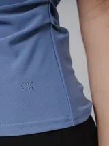 Blusa azul sin mangas de crêpe con cuello alto tipo mock y detalle fruncido.