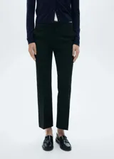 Pantalón negro de tejido fluido con tiro medio, corte flare y diseño largo.