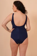 Malla entera de lycra azul marino y blanco, con breteles anchos y escote en V. Tiene un aplique metálico en el centro del escote y un bolsillo interno para colocar una copa removible o prótesis externa.
