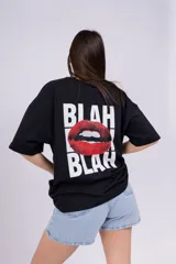 Remera negra de corte amplio con estampado en la espalda que incluye la palabra "BLAH" en mayúsculas y una boca roja.