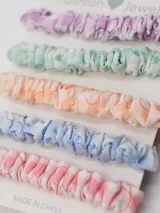 Set de cinco colitas de pelo con elástico, de tela estampada a cuadros en colores pastel: lila, verde, naranja, celeste y rosa.