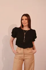 Blusa negra de lino con mangas abullonadas y puños elásticos.