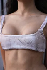 Conjunto de microtop y pantie con estampado de la marca. Microtop con breteles regulables y lazo en la espalda para ajustar. Pantie suelto fruncido con etiqueta de la marca en el frente.