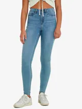 Pantalón de jean celeste, de corte skinny, tiro alto y largo hasta el tobillo.