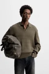 Polo color verde oliva de corte regular, tejido de punto con mezcla de algodón y cashmere. Tiene cuello solapa con cierre frontal de botonadura, manga larga y acabados en rib.