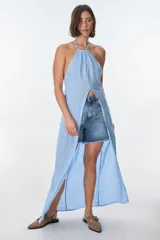 Conjunto de top halter con abertura en el abdomen y falda cruzada con ruedo desflecado, color fucsia.