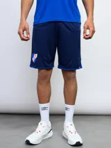 Short de fútbol azul marino con ribetes azules en los bordes. Lleva el escudo del Club Nacional de Football estampado en la pierna izquierda.