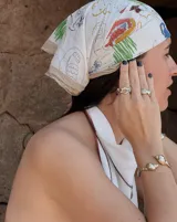 Brazalete rígido dorado con forma de caracola en los extremos.