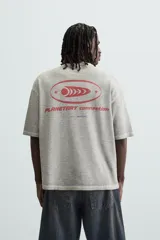 Camiseta gris de punto con cuello redondo y manga corta. Estampado combinado a contraste en delantero y espalda con la frase "Planetary Connection" y un diseño abstracto en rojo.