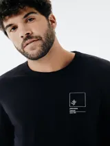 Remera verde militar de manga larga con estampa rectangular frontal de una moto antigua.
