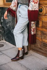 Botín de cuero con estampado de piel de serpiente en tonos marrón y rojo, con elásticos laterales plateados y tacón cuadrado.