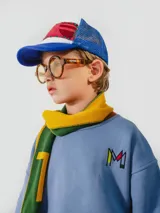 Bufanda azul y marrón con pompones grises, confeccionada en algodón.