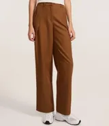 Pantalón recto color marrón confeccionado en cupro, con trabillas en la cintura, cierre tradicional y superposición lateral.