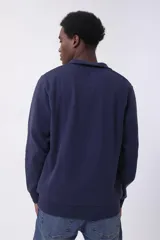 Buzo de friza gris con cuello alto y cierre parcial con cremallera.