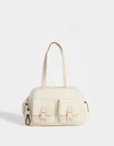 Cartera bowling color crema de tela deportiva con doble asa corta, cierre superior y múltiples bolsillos externos con hebillas y broches. Incluye charm lateral.