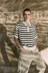 Polo de punto color crema con rayas horizontales verde oscuro, cuello clásico y cierre de botones.