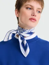 Pañuelo de seda blanco con estampado azul de motivos geométricos y texto. Colección Les Artisans de Paris de Longchamp.