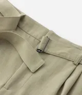 Pantalón de vestir color verde oliva, de corte relaxed, con cinturón con hebilla y pliegues delanteros.