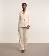 Blazer oversized color beige confeccionado en tweed. Posee cuello inglés, mangas largas, detalles de botones aplicados y solapas que imitan bolsillos.