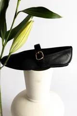 Ballerinas negras de cuero con tira sobre el empeine y hebilla dorada.