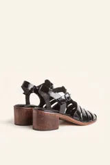 Sandalias de cuero color borgoña con tiras entrecruzadas, hebilla lateral y taco de madera.